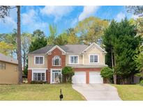 Charming two-story home featuring a brick and siding exterior, a two-car garage, and a well-maintained lawn with beautiful trees at 577 Mountain Oaks Pkwy, Stone Mountain, GA 30087