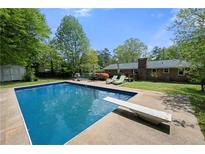 Backyard pool featuring a diving board and surrounding patio, perfect for outdoor enjoyment at 690 Manor Ridge Sw Dr, Mableton, GA 30126