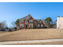 Two-story brick home featuring a manicured lawn, symmetrical windows, and a black front door at 104 Lumby Ln, Stockbridge, GA 30281