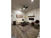Cozy living room features decorative wall, fireplace, modern fan, and neutral color palette at 105 Meadowview Dr, Temple, GA 30179