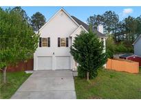 Charming two-story home with a two-car garage and well-manicured front lawn at 1389 Shadow Creek Ave, Hampton, GA 30228