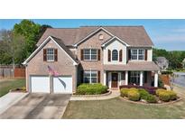 Charming two-story brick home featuring a well-manicured lawn and a two-car garage at 209 Crestmont Way, Canton, GA 30114