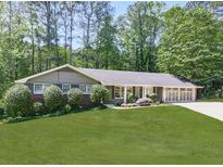 Charming single-story home featuring a well-manicured lawn, beautiful landscaping, and an attached two car garage at 4307 Smithsonia Ct, Tucker, GA 30084