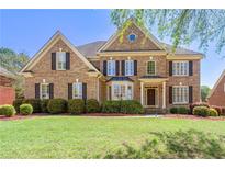 Elegant brick home with manicured lawn and mature landscaping offers great curb appeal at 562 Grassmeade Way, Snellville, GA 30078