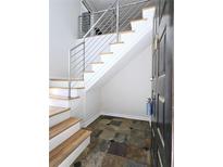 Entryway staircase features modern stainless steel railings and natural wood treads over neutral stone tile at 1490 N Crossing Circle Ne Cir # 1490, Atlanta, GA 30329
