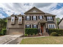 Charming two-story home with a two-car garage, brick accents, and well-maintained landscaping at 3880 Deer Run Dr, Cumming, GA 30028