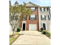 Charming townhome with a well-maintained brick facade, lush greenery, and a spacious driveway at 5401 Fox Creek Lane, Norcross, GA 30071