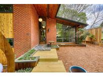 Striking brick home with a wood-plank walkway, modern lighting, and expansive windows at 151 Rockmart Dr Sw, Atlanta, GA 30314
