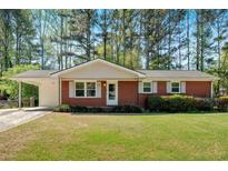 Charming brick ranch-style home featuring a carport and a well-maintained lawn at 3393 Ridgecrest Dr, Powder Springs, GA 30127