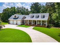 Charming home featuring a spacious front yard, long driveway and inviting front porch with columns at 4149 Yancey Rd, Douglasville, GA 30135