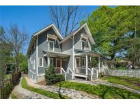 Charming two-story home with a inviting front porch and well-manicured lawn on a bright sunny day at 1100 Wylie Se St # A, Atlanta, GA 30316