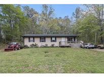 Charming ranch-style home with a well-maintained lawn and mature trees at 1302 Brittain Rd, Douglasville, GA 30134
