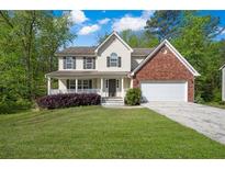 Charming two-story traditional home featuring a manicured front yard and a brick-accented attached two-car garage at 2979 Sweetbriar Walk, Snellville, GA 30039