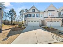 Charming two-story home with symmetrical facade, double garage, driveway and manicured lawn in a suburban neighborhood at 1041 Cherryfield Run, Marietta, GA 30008