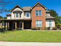 Inviting two-story home showcasing brick and tan siding, complete with a well-manicured lawn and covered porch at 533 Mount Gerizim Se Rd, Mableton, GA 30126
