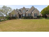 Inviting brick home featuring a manicured front lawn and mature landscaping, enhancing its curb appeal at 5604 Mccullers Ln, Loganville, GA 30052