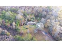 A tranquil aerial view showcasing the home nestled amidst a lush forest backdrop and expansive lot at 98 Almon Church Rd, Covington, GA 30014