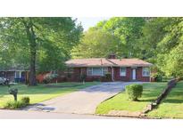 Charming brick home features a well-manicured lawn and a long driveway leading to the entrance at 2685 Buena Vista Ave, Doraville, GA 30340