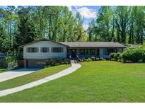 Charming one-story home with a well-maintained lawn and inviting walkway surrounded by mature trees at 2920 Dara Dr, Marietta, GA 30066