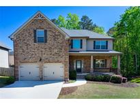 Charming two-story brick home featuring a two-car garage and a welcoming front porch at 3228 Trinity Mill Cir, Dacula, GA 30019