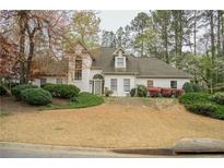 Charming white home featuring a manicured lawn and mature trees at 5713 Brynwood Nw Cir, Acworth, GA 30101