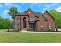 Stately brick home with manicured lawn and mature trees offering classic curb appeal at 6048 Golf View Xing, Locust Grove, GA 30248