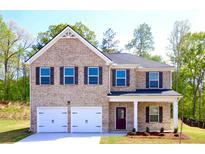 Charming two-story home features a brick facade, attached two car garage, and well-maintained landscaping at 663 Egrets Landing Lot #55, Covington, GA 30014