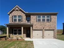 Beautiful two-story brick home featuring a two-car garage and covered front porch at 663 Egrets Landing Lot #55, Covington, GA 30014