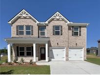 Charming two-story brick home with a two-car garage, covered entryway, and dark shutters at 669 Egrets Lot 56 Lndg, Covington, GA 30014