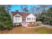 Charming home featuring a brick facade, red shutters, a bay window and a well-manicured lawn at 1074 Fieldstone Dr, Canton, GA 30114