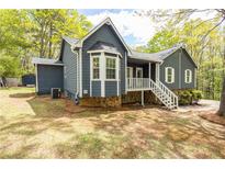 Charming home featuring a blue exterior, white trim, bay window and lovely stone accents on the foundation at 2724 Bomar Rd, Douglasville, GA 30135