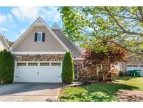 Charming home featuring a stone facade, two-car garage, and well-manicured lawn at 207 Cole Ct, Canton, GA 30114