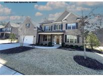 Beautiful two-story brick home featuring a manicured front lawn, black shutters, and a two-car garage at 13015 Fox Rd, Alpharetta, GA 30005