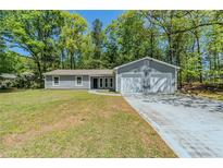 Charming one-story home featuring a two-car garage and a well-maintained front yard at 1665 Dunbarton Dr, Lithonia, GA 30058