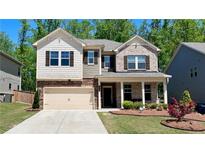 Charming two-story home featuring a brick and siding facade, manicured lawn, and a two-car garage at 1835 Wellston Dr, Lawrenceville, GA 30043