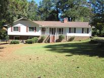 Charming single-Gathering home with well-maintained front lawn, mature trees, and inviting facade at 2107 Briarwood Ct, Snellville, GA 30078