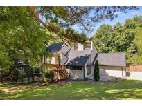 Stylish home with a black roof, wooden stairs, and a spacious front yard with ample green space at 2295 Piedmont Ridge Ct, Marietta, GA 30062