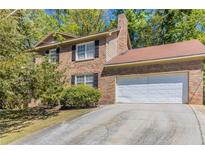 Charming brick two-story home with an attached two-car garage and a driveway at 6330 Phillips Pl, Lithonia, GA 30058