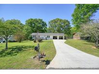 Charming single-story home with a well-manicured lawn, mature trees, and an extra long driveway at 1214 Marshall Fuller Rd, Dallas, GA 30157