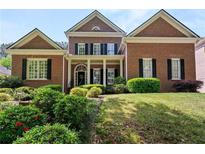 Charming brick home featuring a meticulously landscaped front yard and a welcoming columned entrance at 4862 Tarry Post Ln, Suwanee, GA 30024