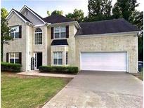 Charming two-story home with a well-manicured lawn and an attached two-car garage at 220 Cameron Ways, Covington, GA 30016