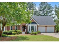 Charming brick home with well-maintained lawn, mature trees, and two-car garage at 4508 Club House Dr, Marietta, GA 30066