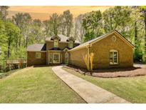 Charming two-story brick home with a well-maintained lawn and inviting walkway at 1660 Weems Rd, Locust Grove, GA 30248