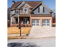 Charming two-story home featuring a stone and brick facade with a well-manicured front yard at 9989 Village South Dr, Douglasville, GA 30135