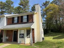 Charming two-story townhome with brick accents and a well-maintained front lawn at 1477 Springleaf Se Cir, Smyrna, GA 30080