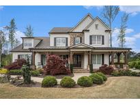 Charming two-story home featuring a covered front porch, beautiful landscaping, and a combination of stone and painted brick at 3039 Malbec Vly, Acworth, GA 30101
