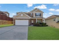 Charming two-story home with stone accents, well-manicured lawn, and a two car garage at 679 Barley Hill Ln, Sugar Hill, GA 30518
