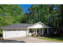 Charming ranch-style home with inviting porch and well-manicured lawn nestled among mature trees at 1898 Mornington Ln, Snellville, GA 30078