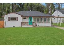 Charming home featuring a teal front door, inviting porch, and a well-manicured lawn at 2681 Tilson Rd, Decatur, GA 30032
