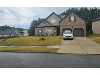 Charming two-story brick home with a well-manicured lawn and two-car garage at 1750 Stone Meadow Rd, Lithonia, GA 30058